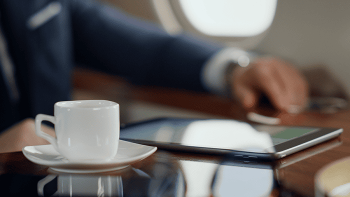 Coffee cup beside tablet on table