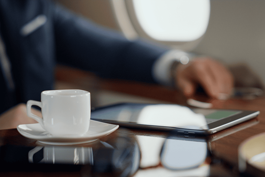 Coffee cup beside tablet on table