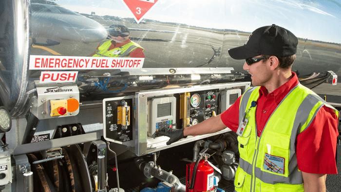 Fuel technician operating fuel truck controls.