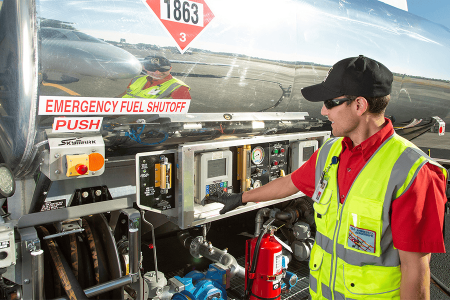 Fuel technician operating fuel truck controls.