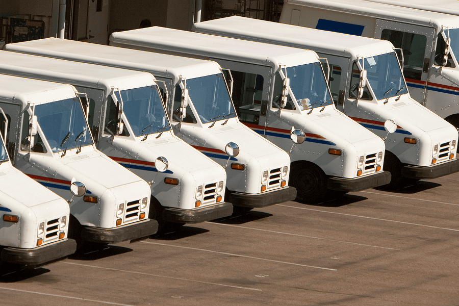 Row of white delivery trucks parked.
