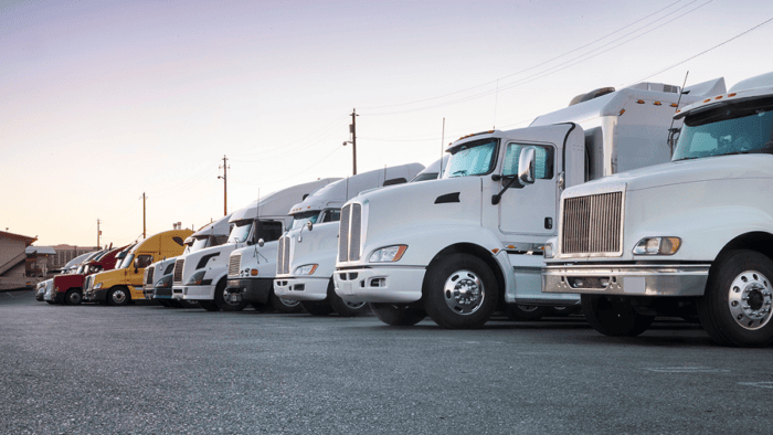 Line of trucks parked at sunset.