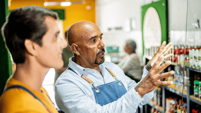 Two men discussing products in store