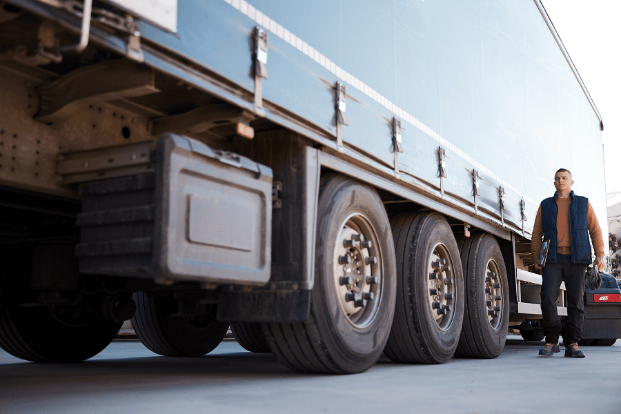 man walking next to semi truck