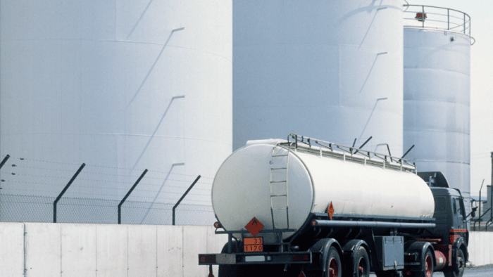 Tanker driving by storage tanks