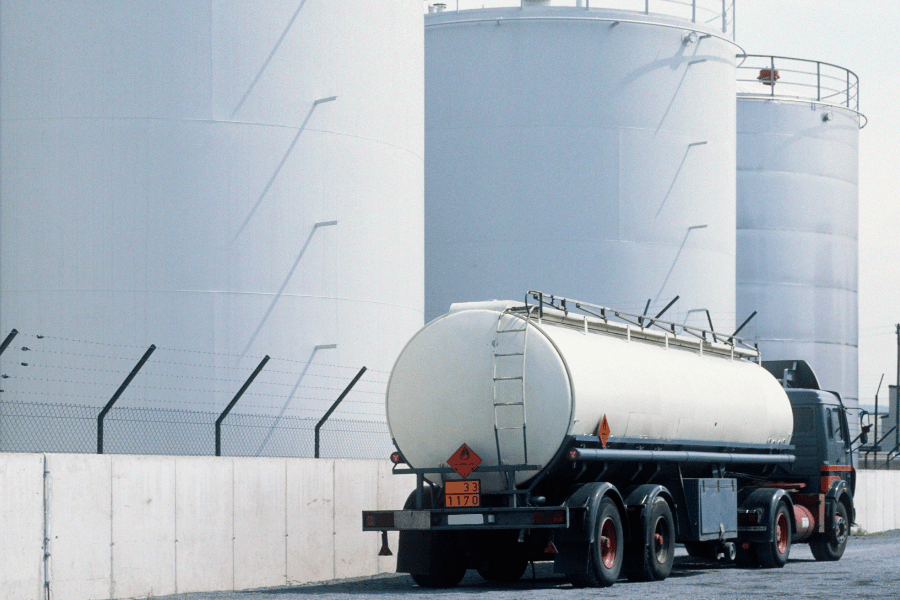 Tanker driving by storage tanks