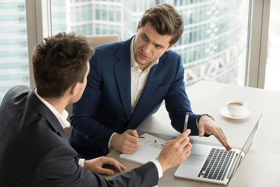 two men sitting in desk speaking