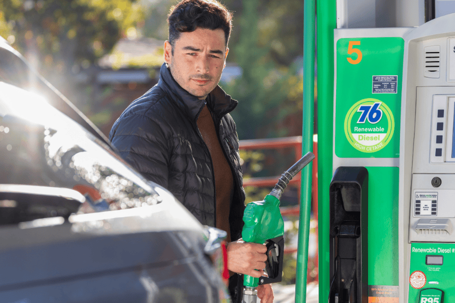 Man holding fuel nozzle at gas station