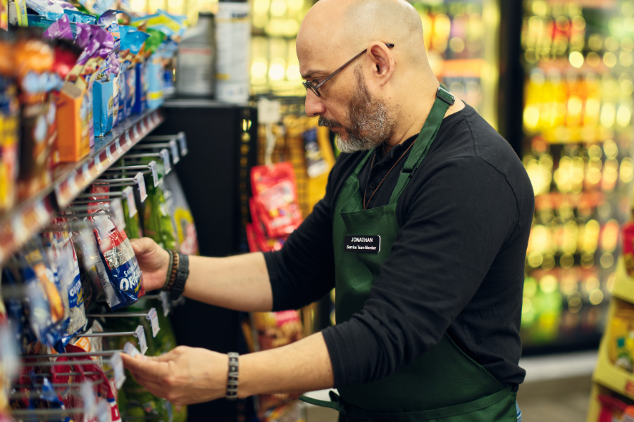 Retail Associate Arranging Products in Convenience Store