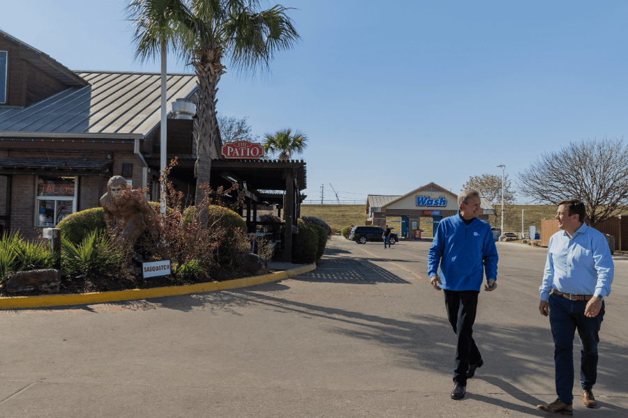 Two men walking in the parking lot of a convenience store