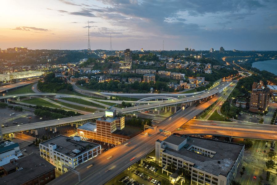 Cincinnati cityscape with roads and buildings at dusk.