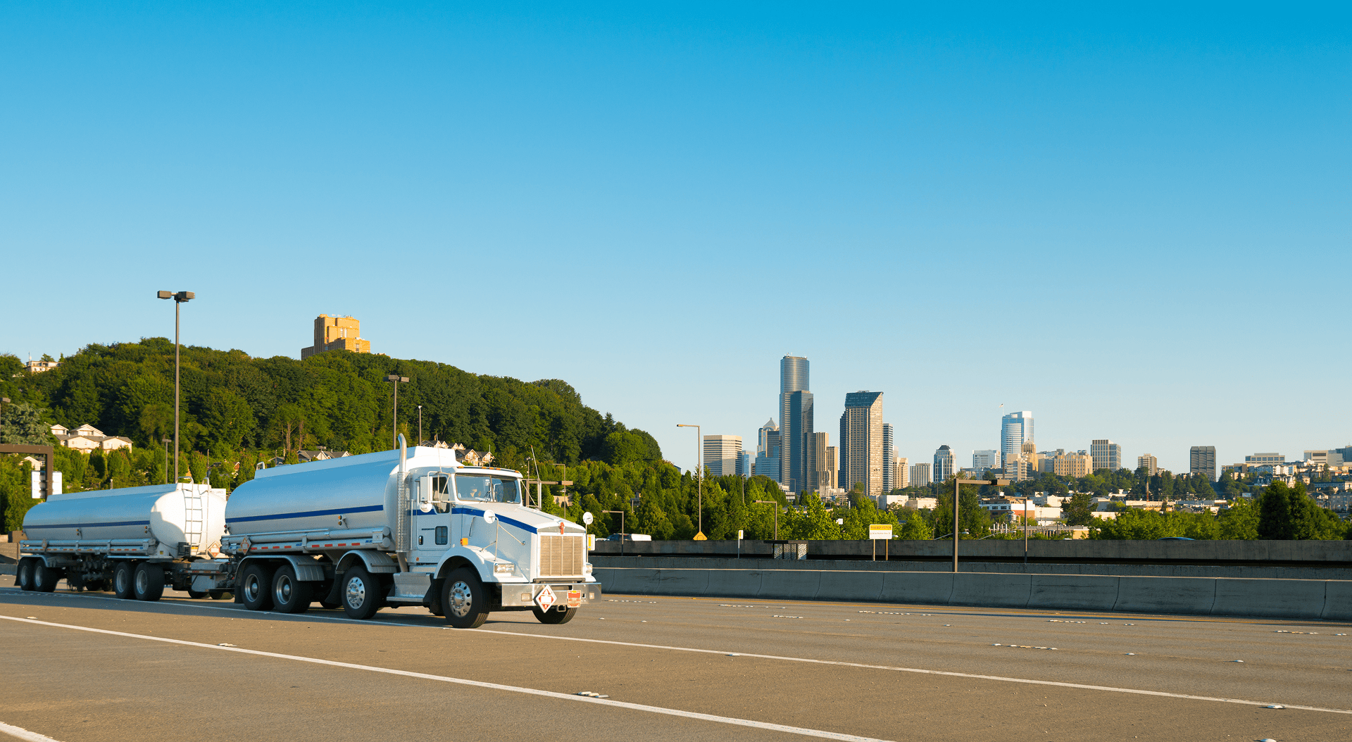 Truck driving towards Seattle skyline.