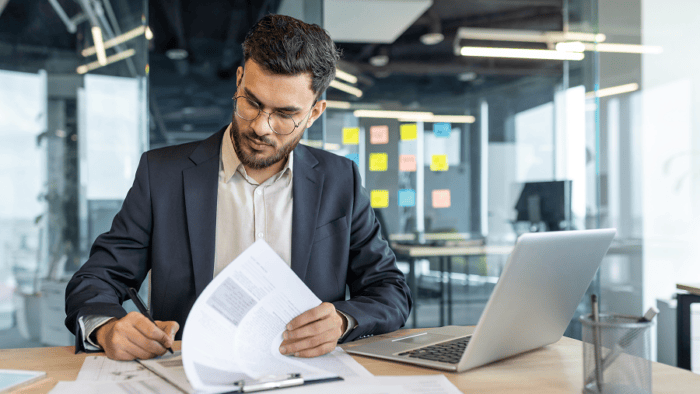 man writing on document
