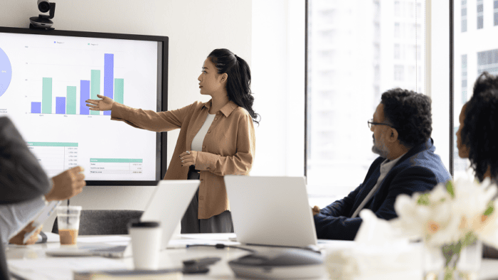 woman presenting graphs to people