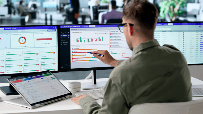 Man analysing data on multiple screens.