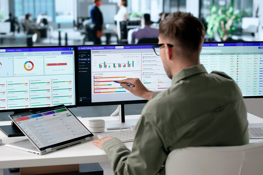 Man analysing data on multiple screens.