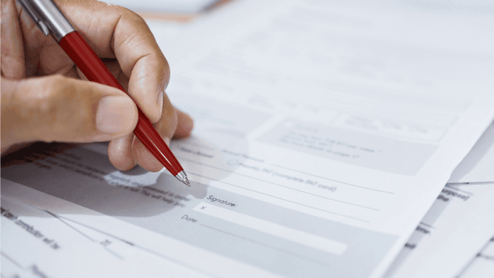 Hand holding pen over document