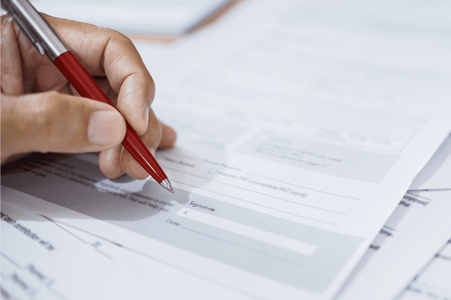 Hand holding pen over document