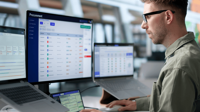 Man analysing data on multiple screens.