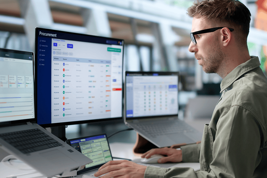 Man analysing data on multiple screens.