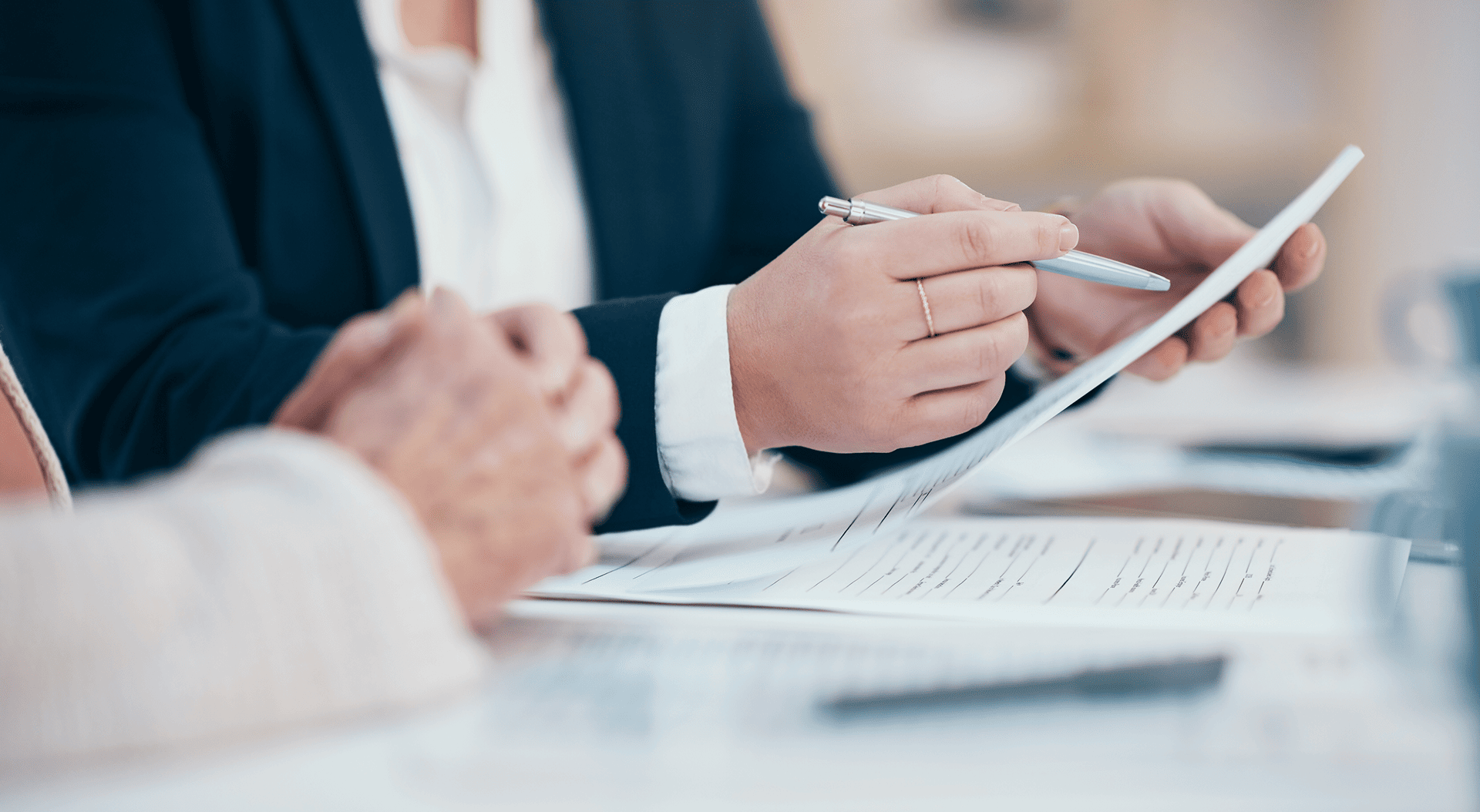 Hands holding documents and pen.