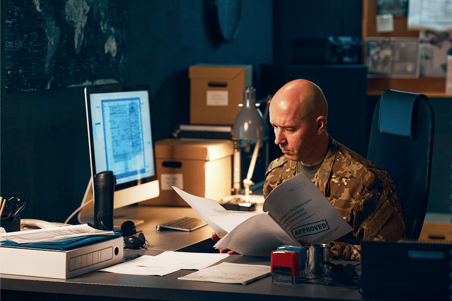 Military personnel analyzing classified documents
