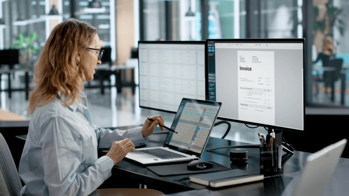 Woman working on financial documents digitally.