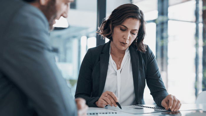 A businessman and businesswoman reviewing contract paperwork