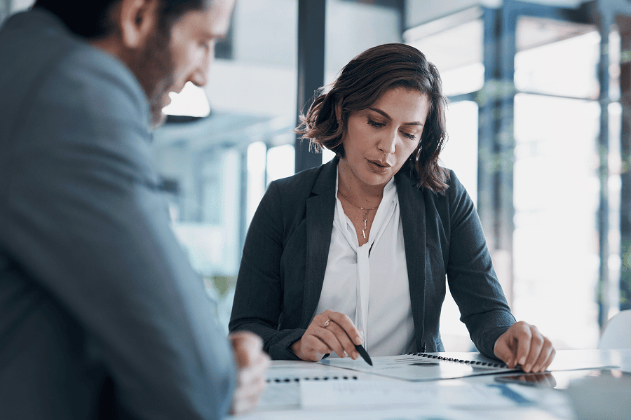 A businessman and businesswoman reviewing contract paperwork