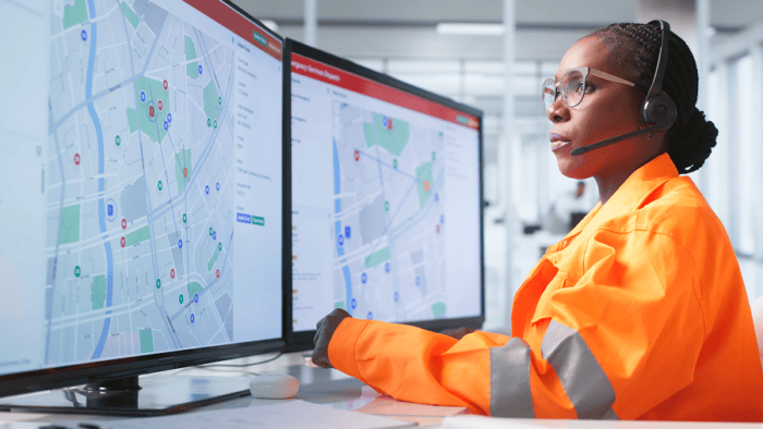 Woman monitoring maps on computers