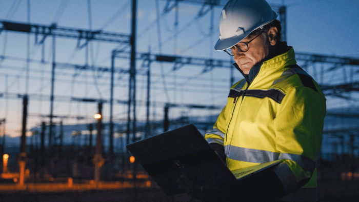 Engineer using laptop at dusk.