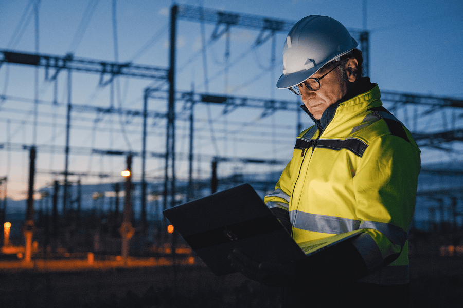 Engineer using laptop at dusk.