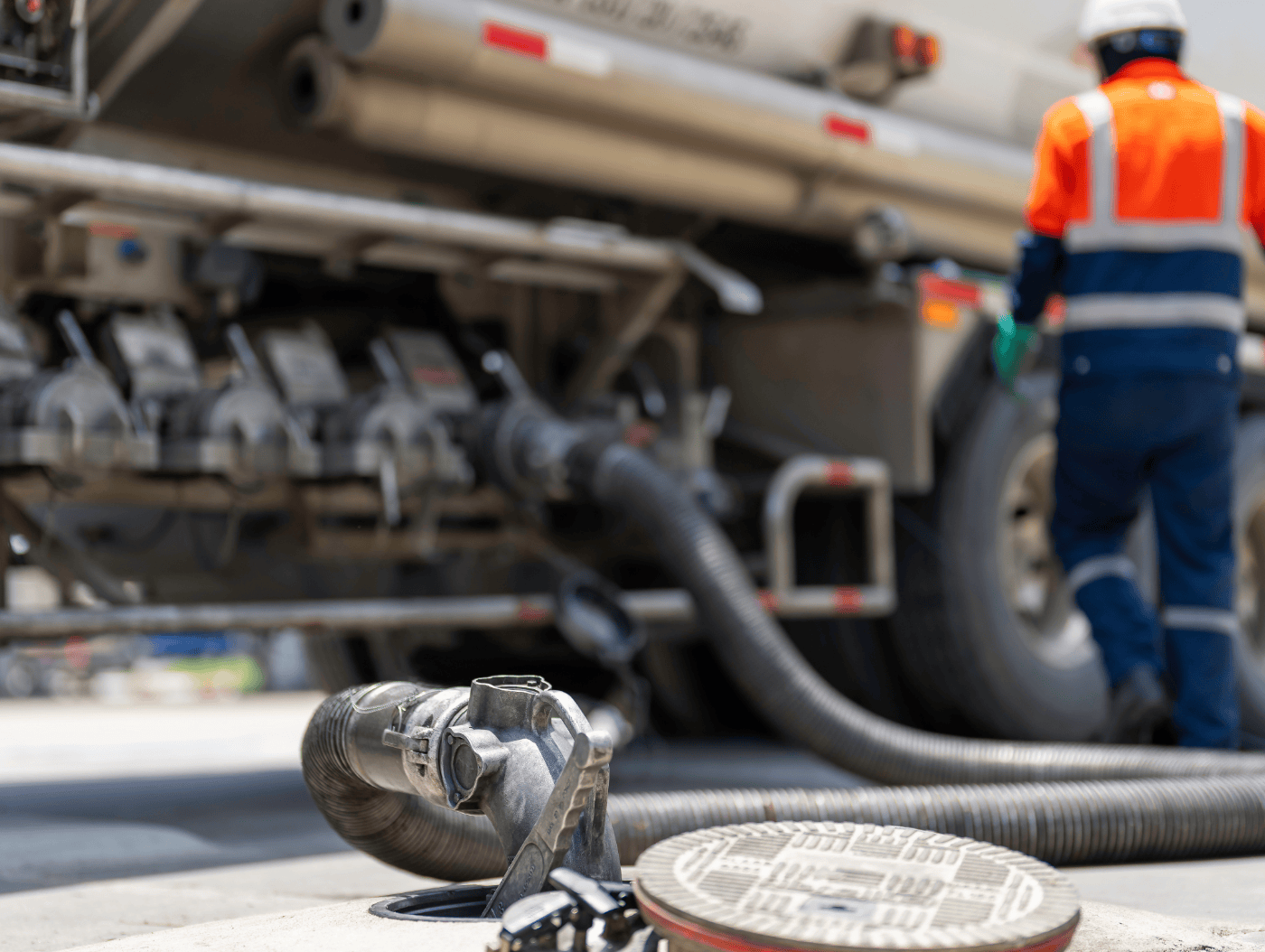 A fuel transfer hose securely connected to an industrial bulk storage tank