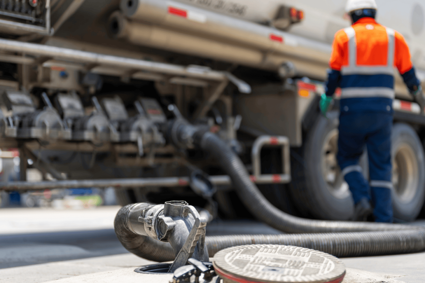 A fuel transfer hose securely connected to an industrial bulk storage tank