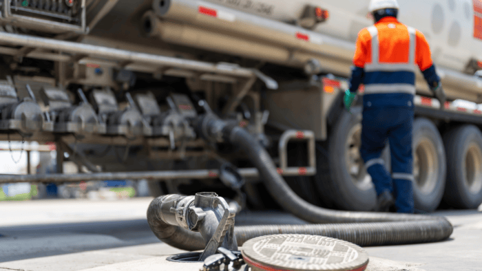 A fuel transfer hose securely connected to an industrial bulk storage tank