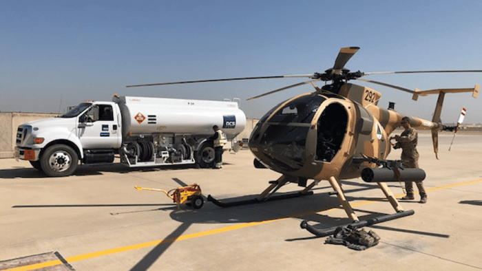 A tactical military helicopter undergoing airfield refueling operation