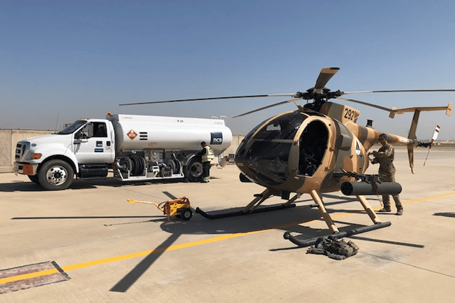 A tactical military helicopter undergoing airfield refueling operation