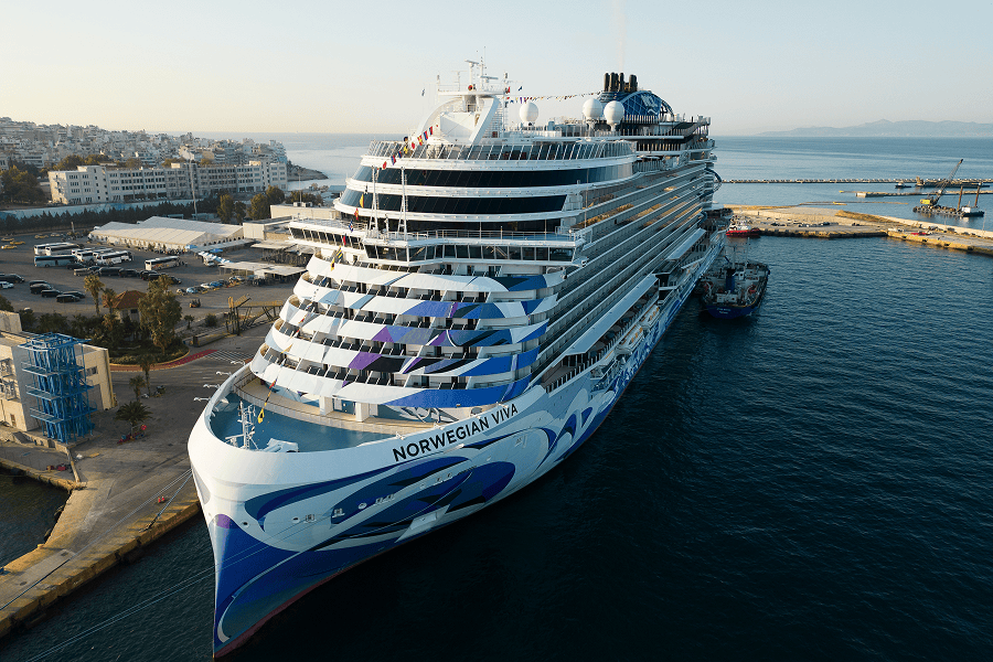 A luxury cruise ship docked securely at a passenger port terminal pier