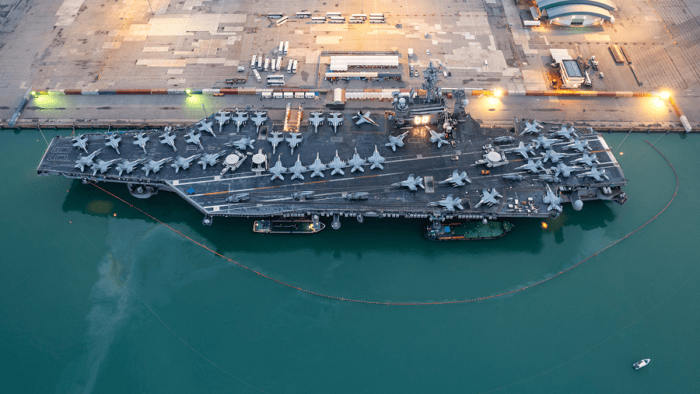 An aircraft carrier with military fighter jets parked on its flight deck