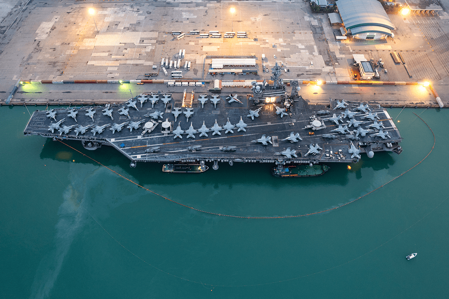 An aircraft carrier with military fighter jets parked on its flight deck