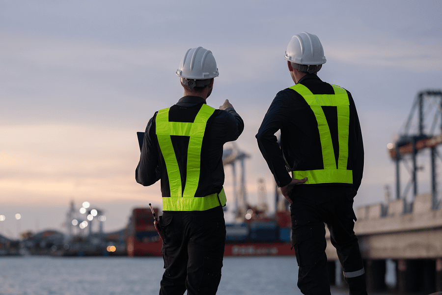 A team of engineers having a discussion on site at a maritime port terminal
