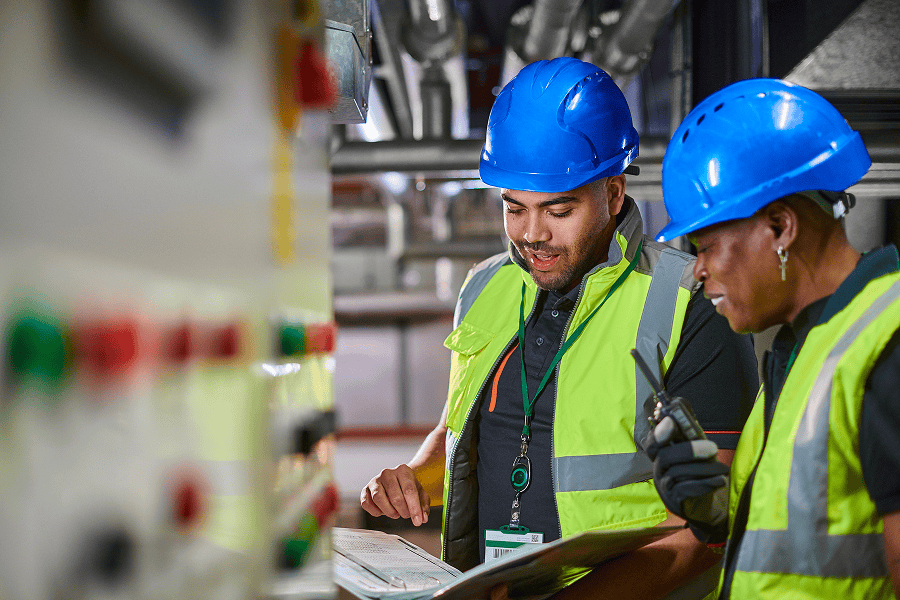 A team of maritime engineers and workers discussing operations inside a commercial fuel processing plant facility