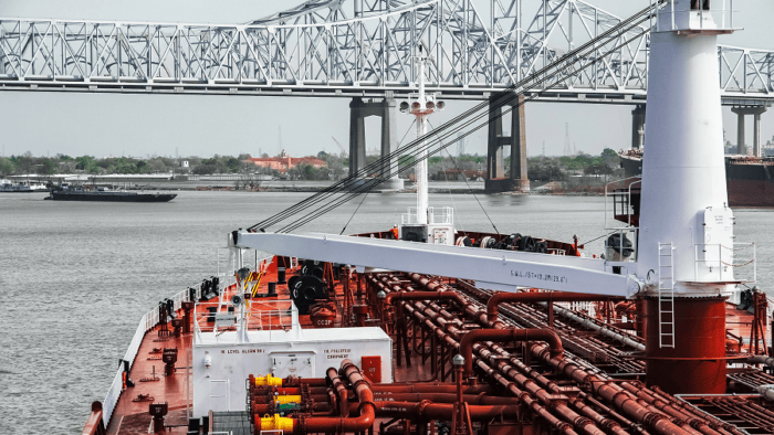 A large commercial vessel passing under a bridge