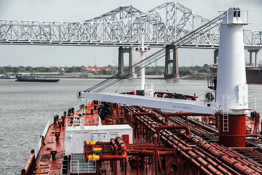 A large commercial vessel passing under a bridge