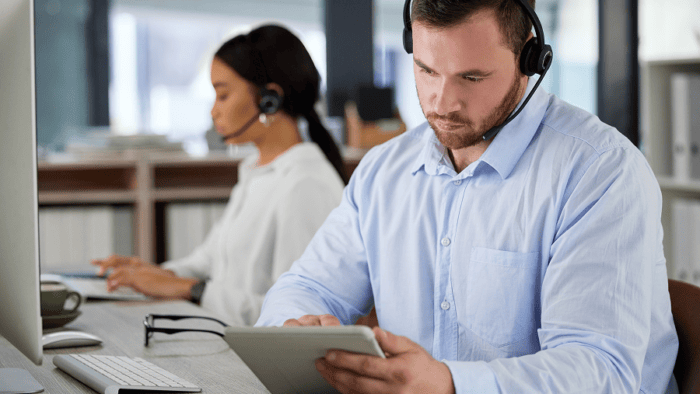 man with headset looking at tablet