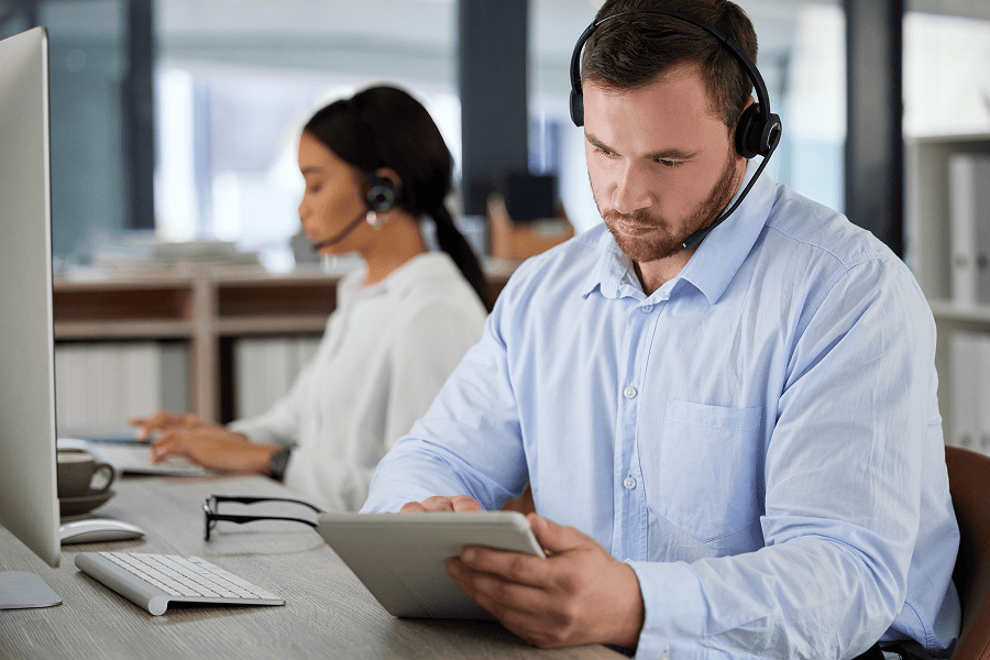 man with headset looking at tablet