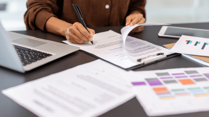 Signing documents at a business desk.
