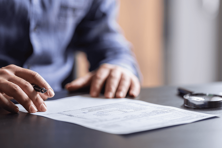 Man reviewing documents with pen.