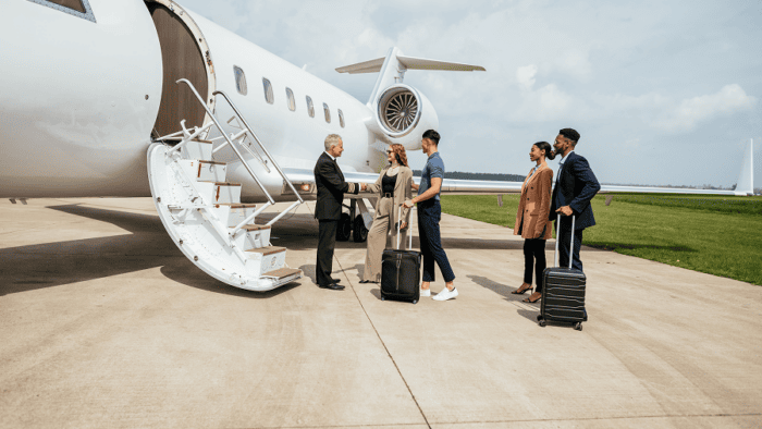 Pilot welcoming passengers at private jet
