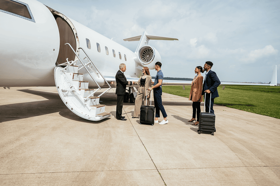 Pilot welcoming passengers at private jet